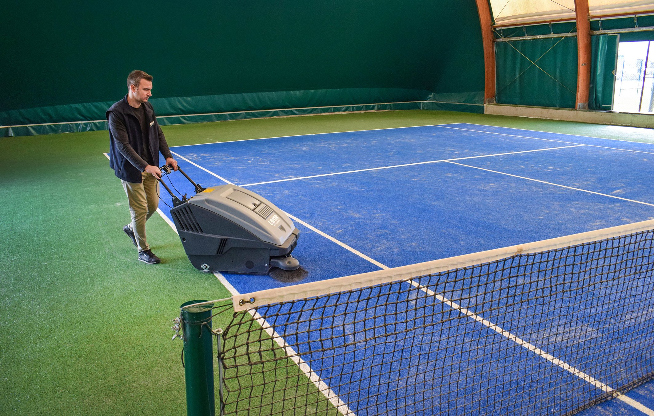 cleaning the padel courts with a sweeper