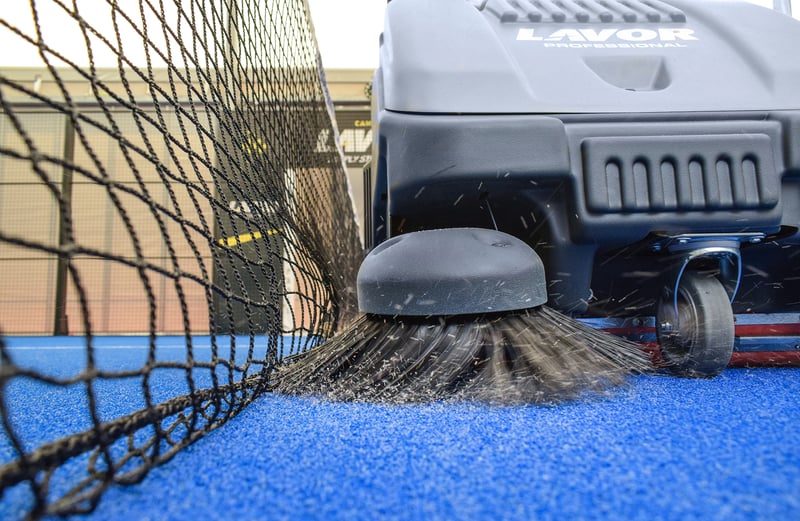 cleaning the padel courts with a sweeper