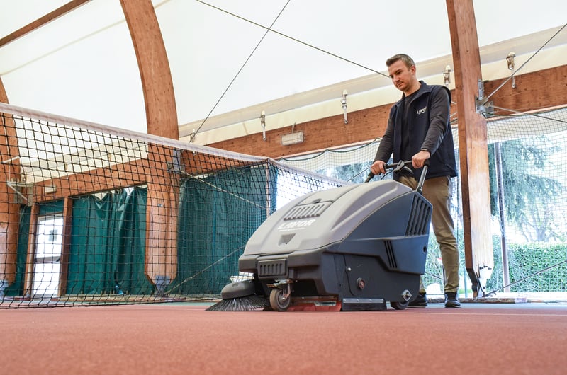 cleaning the padel courts with a sweeper